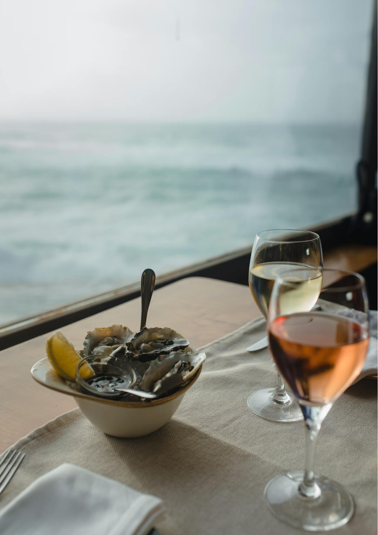 Fresh oysters with wine glasses overlooking the ocean